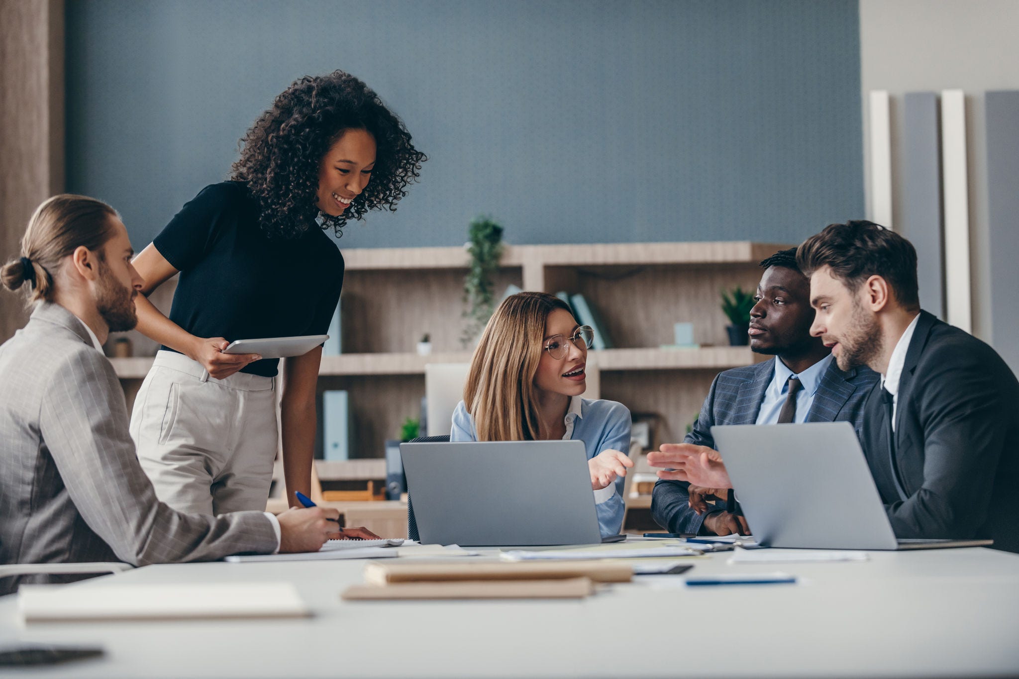 Confident group of business people discussing strategy during team meeting at the office desk 