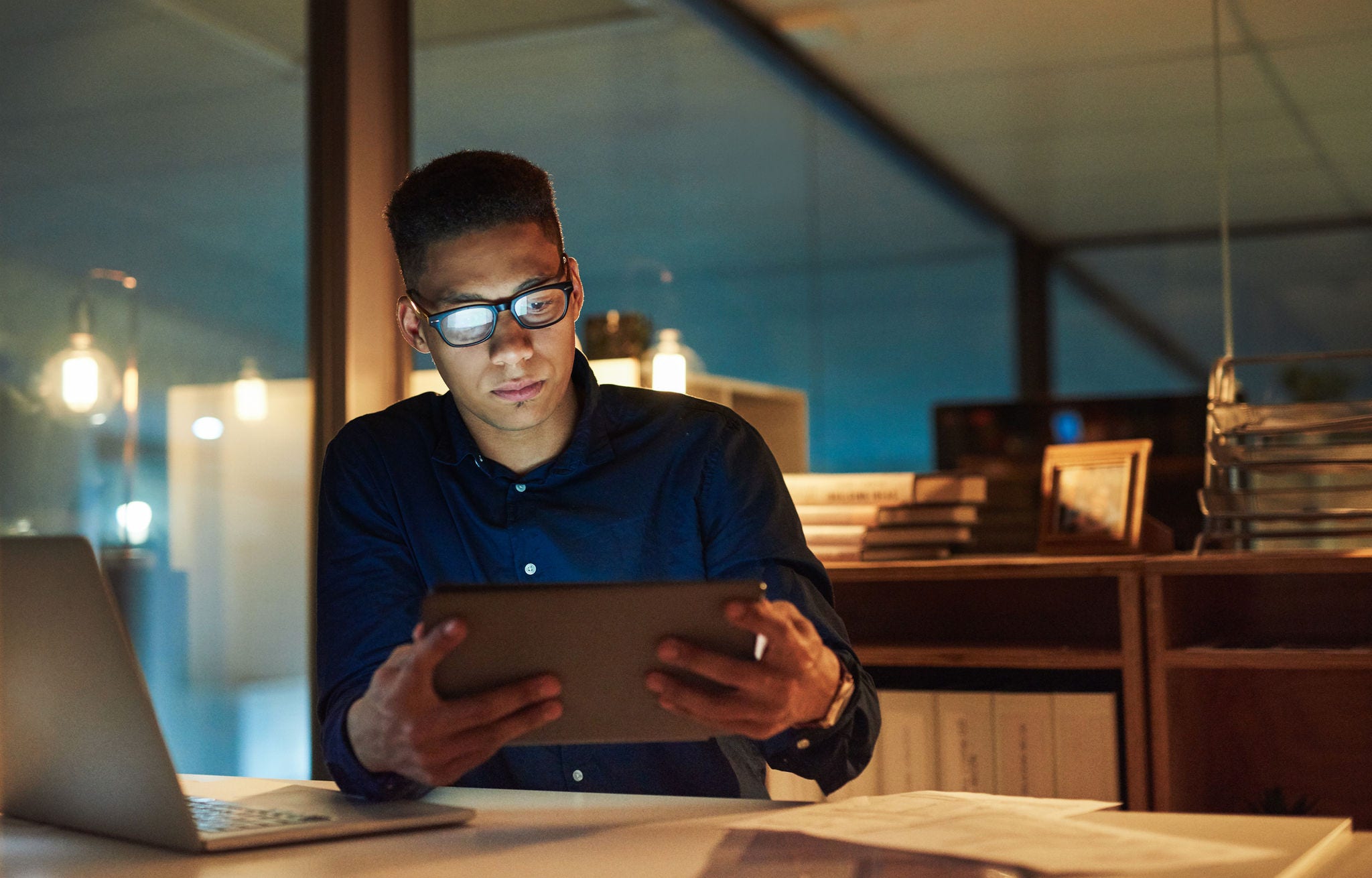 Shot of a young businessman using a digital tablet during a late night at work