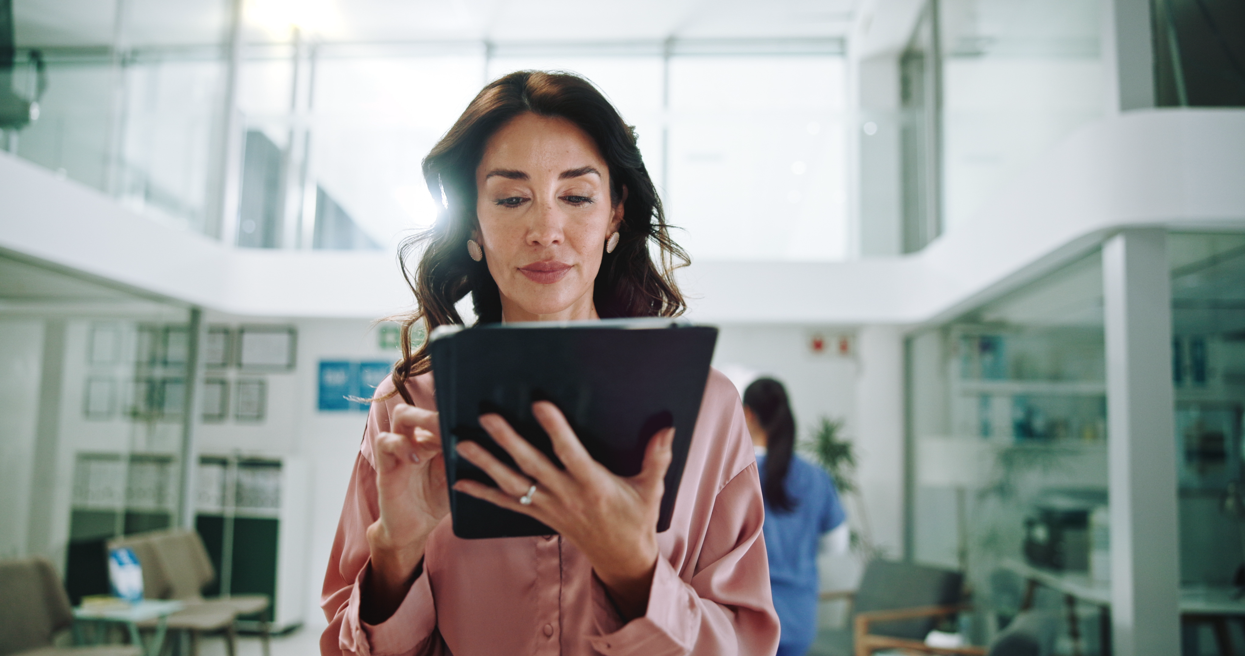 Hospital, consultant and woman on tablet for medical service, results and internet research. Healthcare, clinic and person on digital tech for online administration, planning and insurance on website.