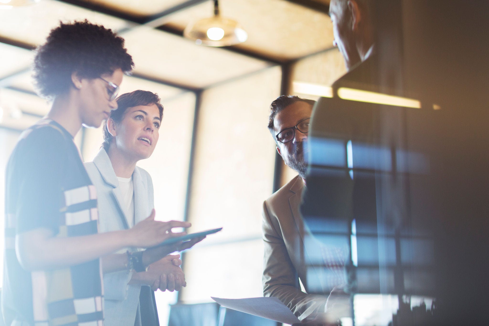 Business people discussing project on digital tablet in creative office