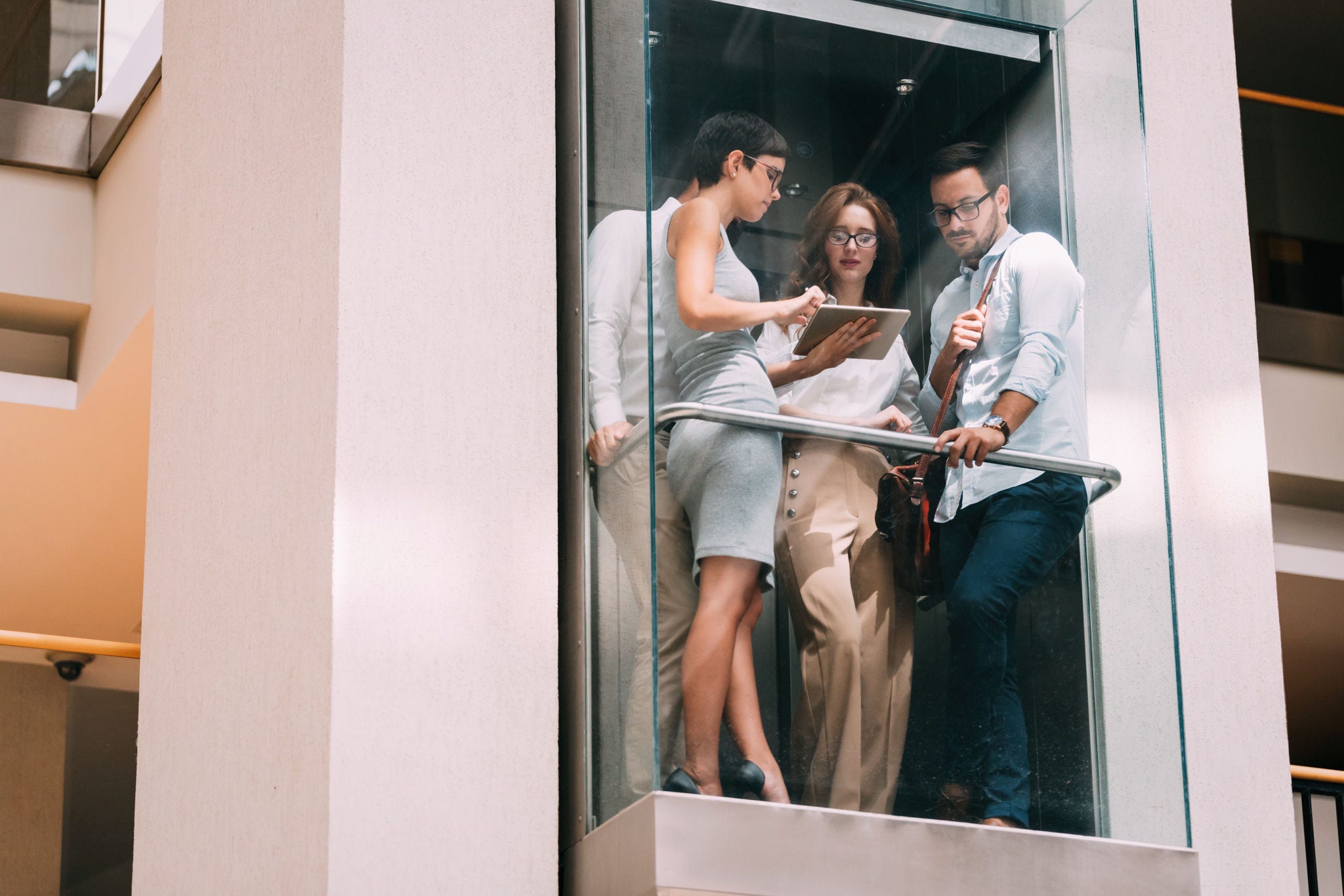 Picture of young attractive businesspeople talking in elevator