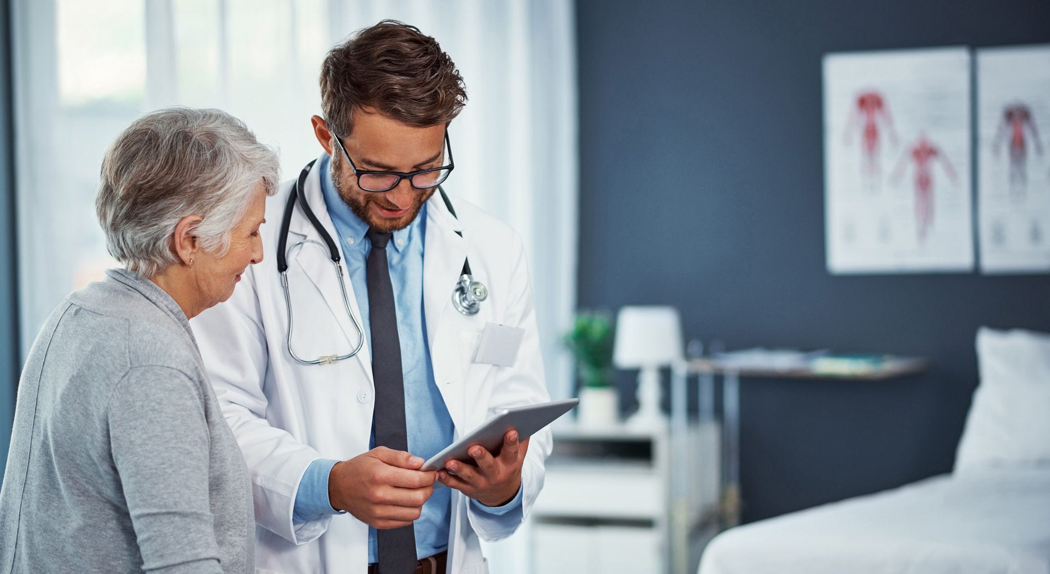 Shot of a doctor discussing something on a digital tablet with a senior patient in a clinic