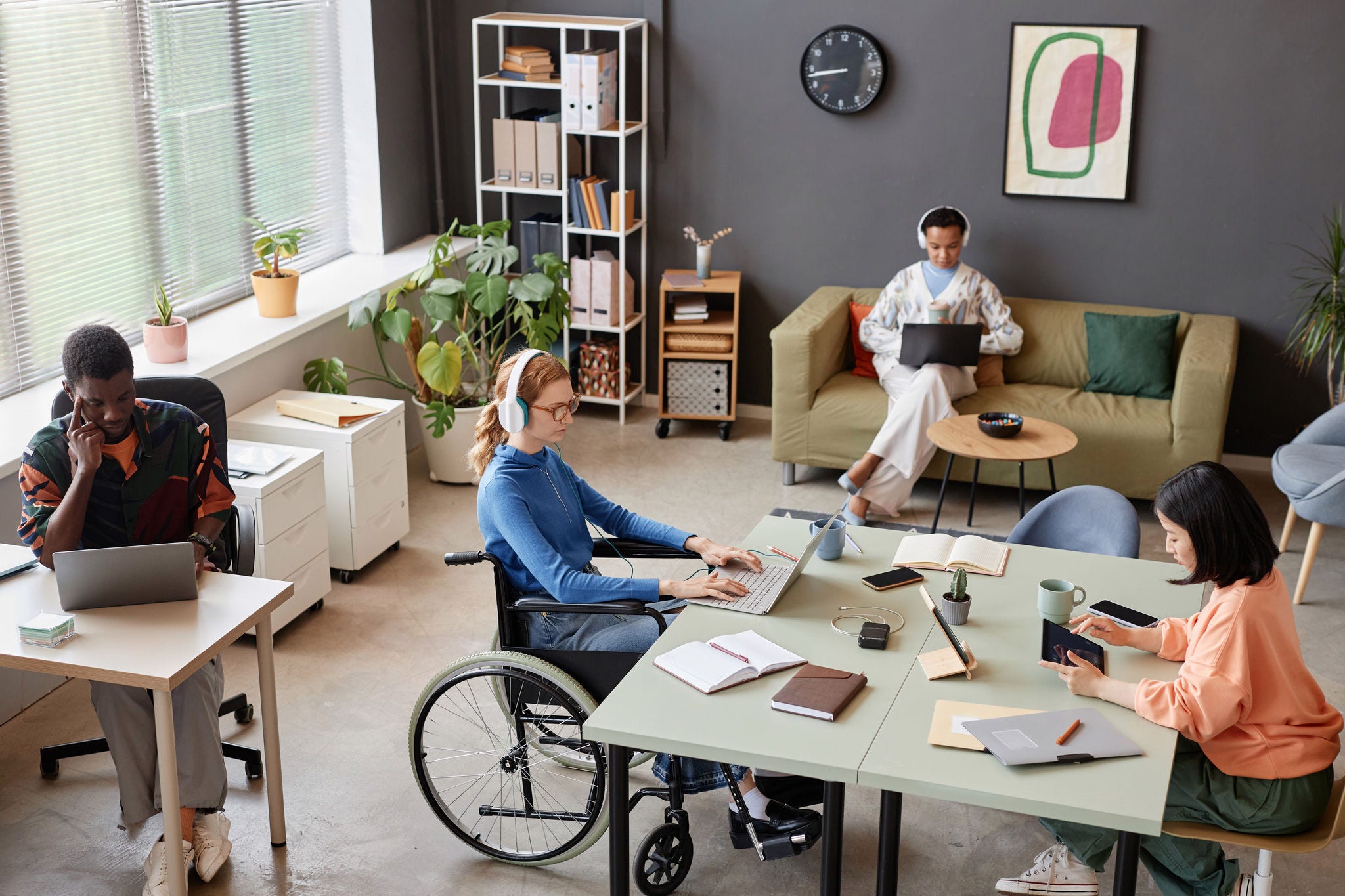 High angle view at modern office with diverse young people working at separate tasks, copy space